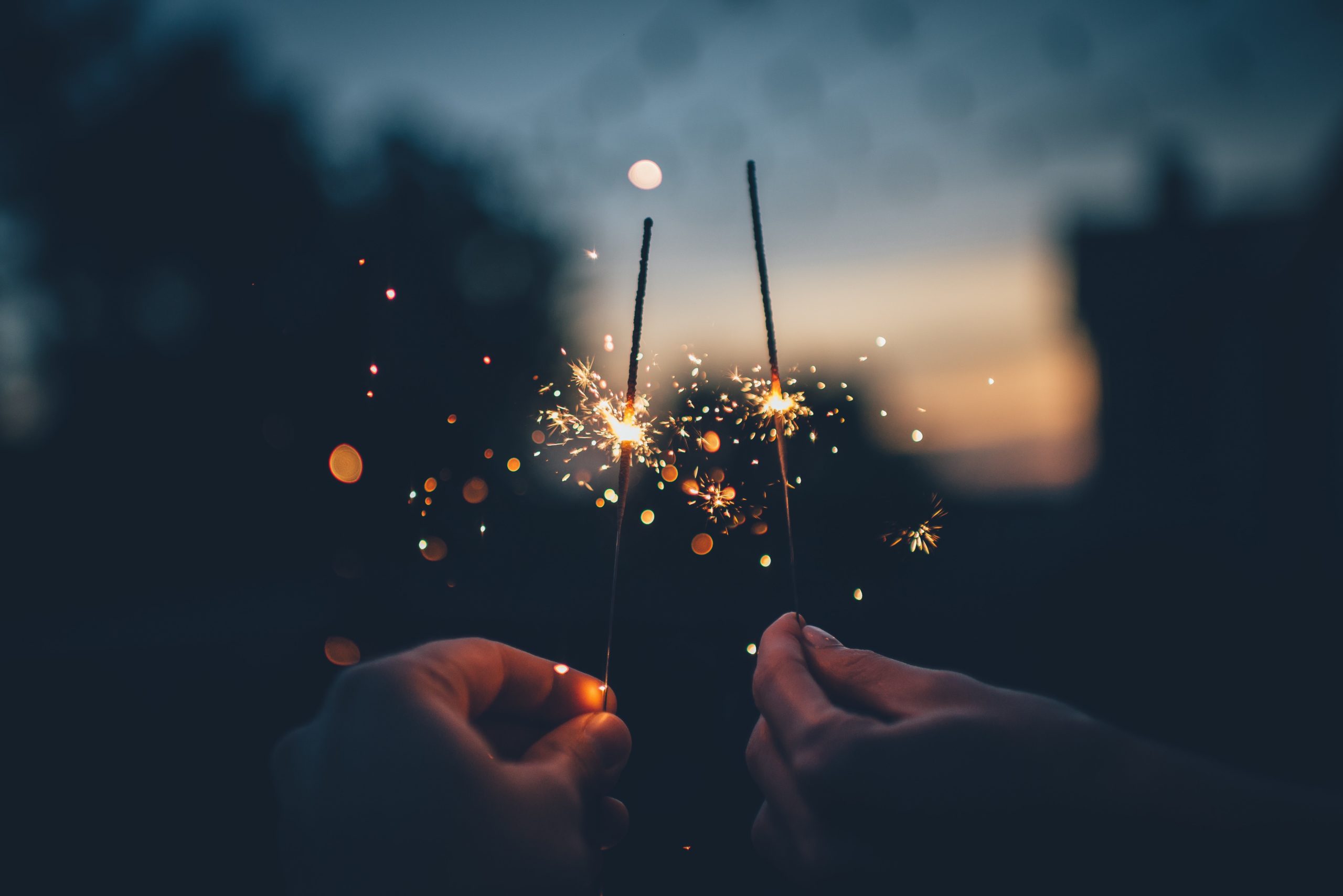 Photo by Ian Schneider person holding fire cracker shallow focus photography